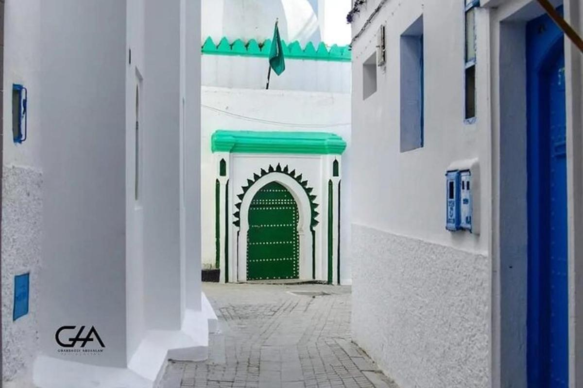 egy zöld ajtó egy sikátorban két fehér épület között