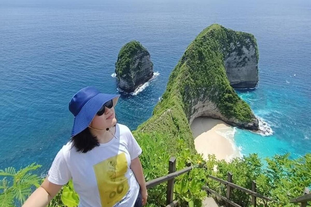 žena stojící na vrcholu hory s výhledem na pláž
