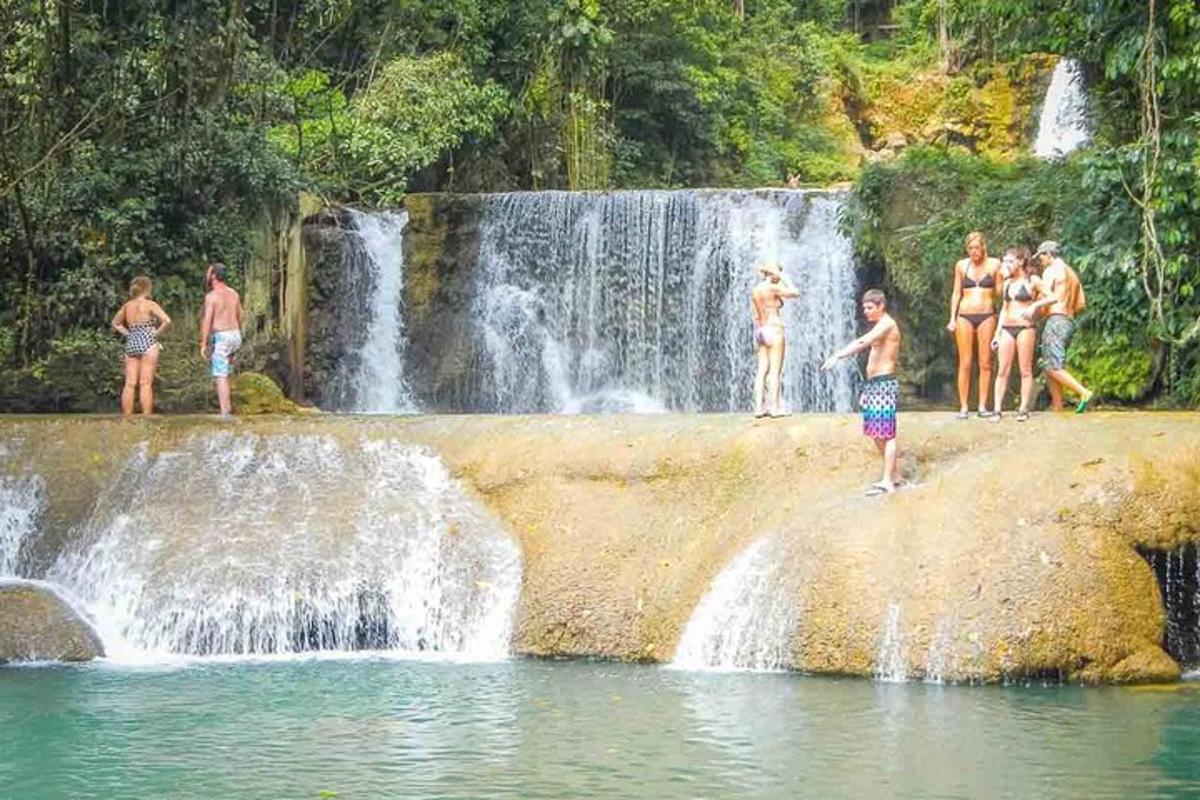 un gruppo di persone in piedi davanti a una cascata