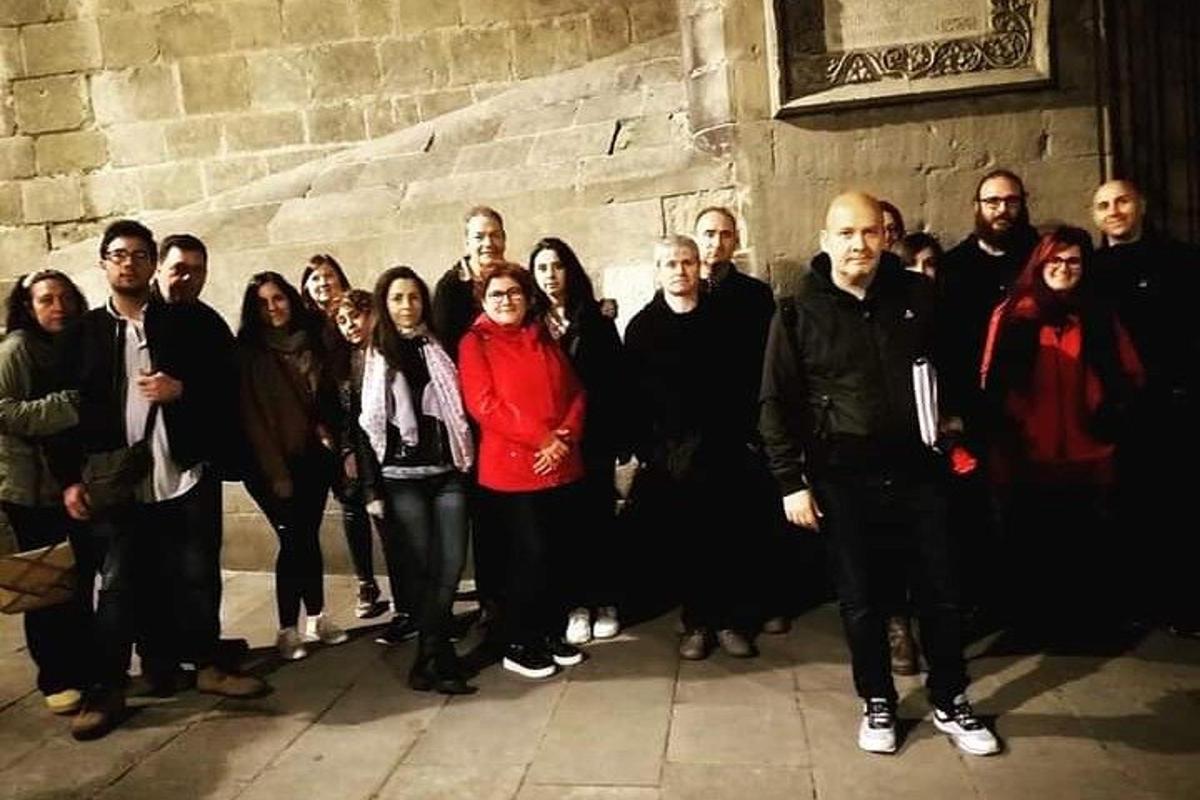 un gruppo di persone in piedi davanti a un muro di pietra