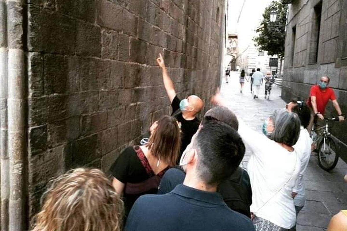 un gruppo di persone in piedi attorno a un muro di mattoni