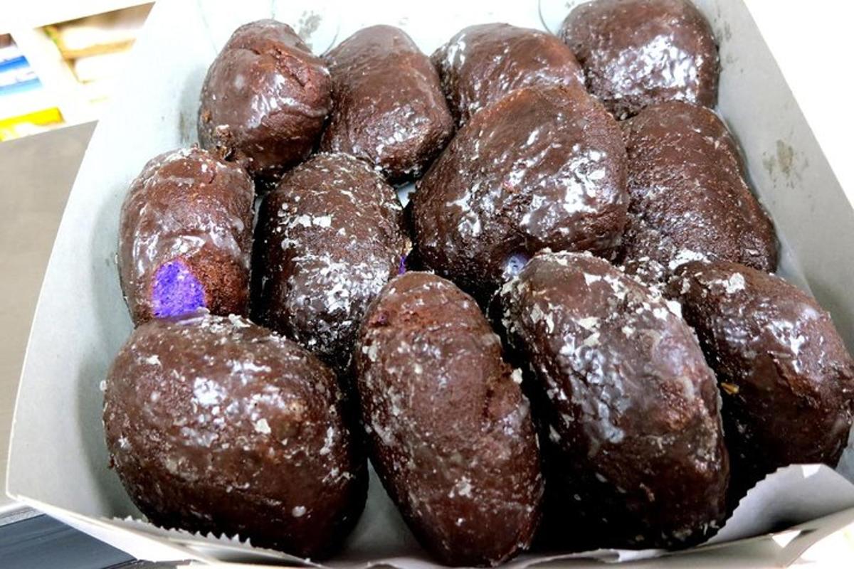 sekotak donat coklat duduk di atas meja