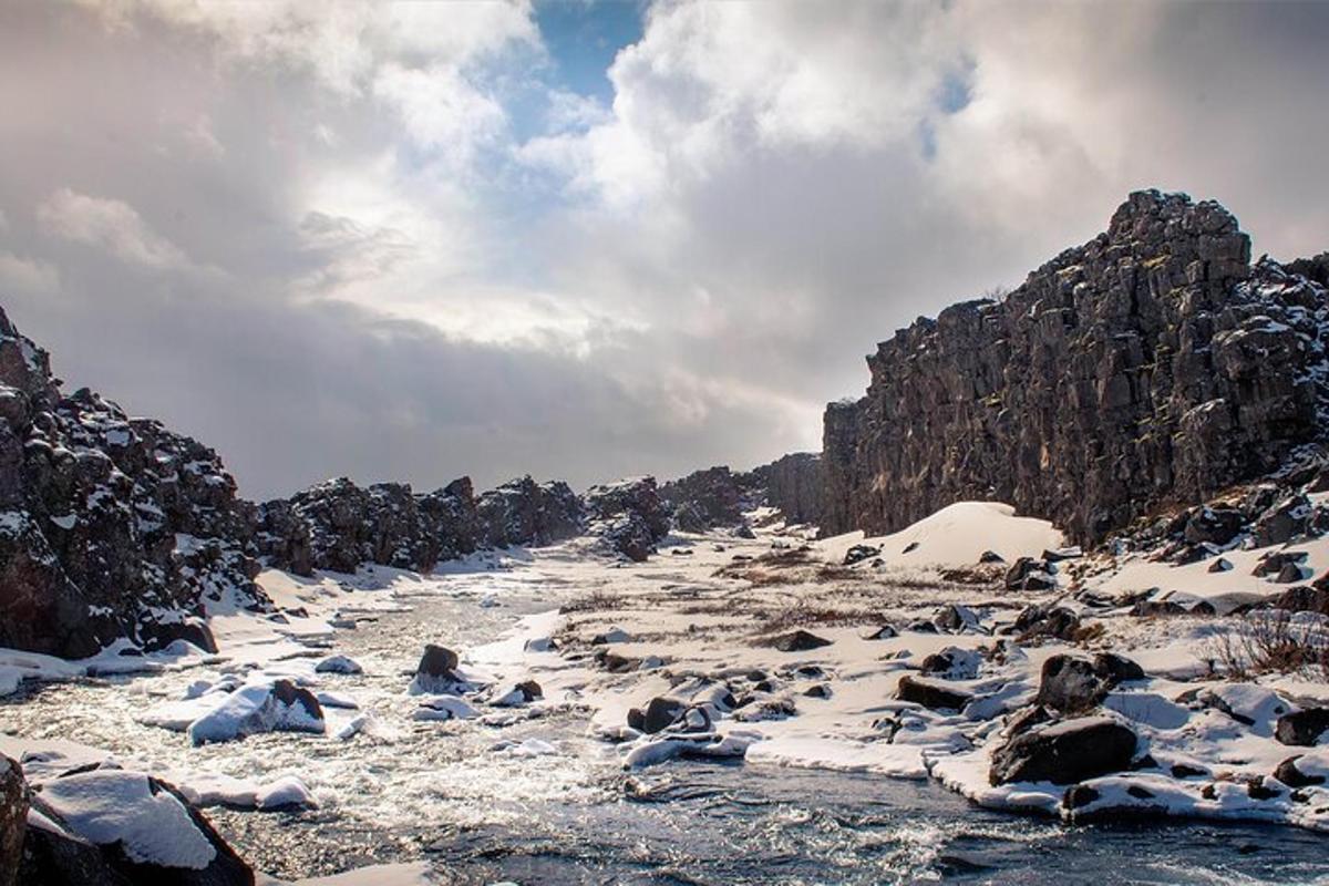 un fiume con la neve sul fianco di una montagna