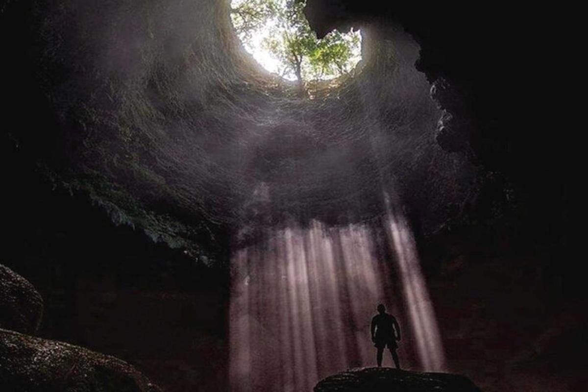 ein Mann steht vor einem Wasserfall