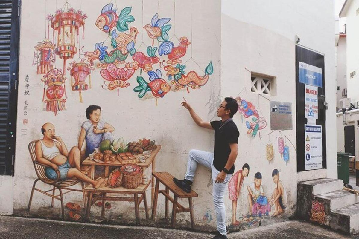 un home dret davant d'una paret amb un mural