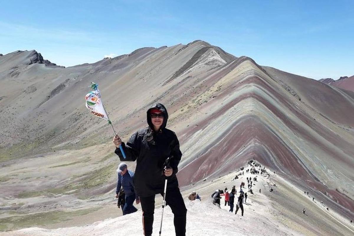 een persoon die een vlieger vasthoudt op de top van een berg