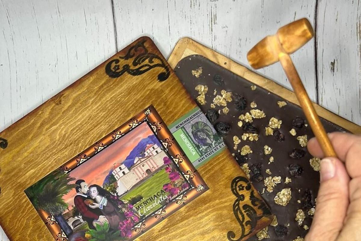 uma pessoa segurando uma colher de pau ao lado de uma pintura sobre uma mesa
