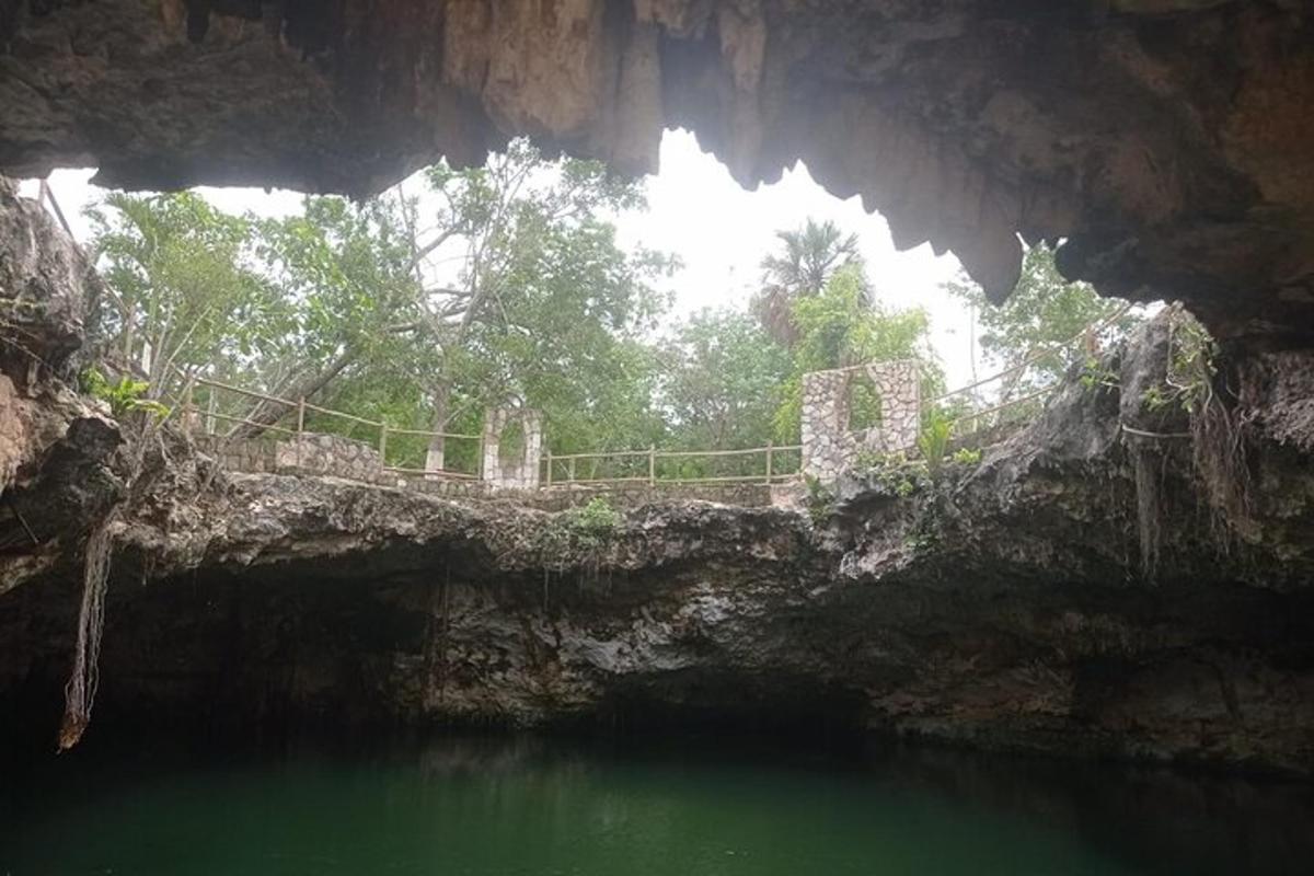 sebuah gua dengan air hijau dan jambatan di latar belakang