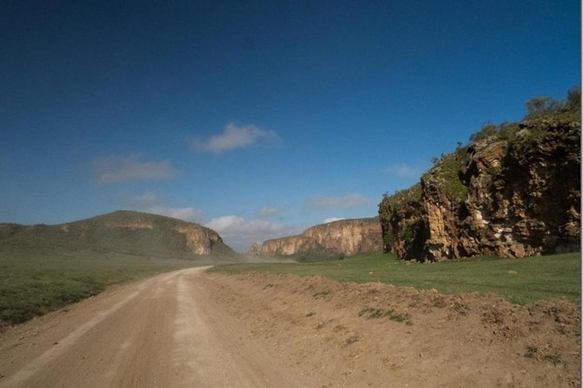eine unbefestigte Straße mitten in einem Feld mit Bergen