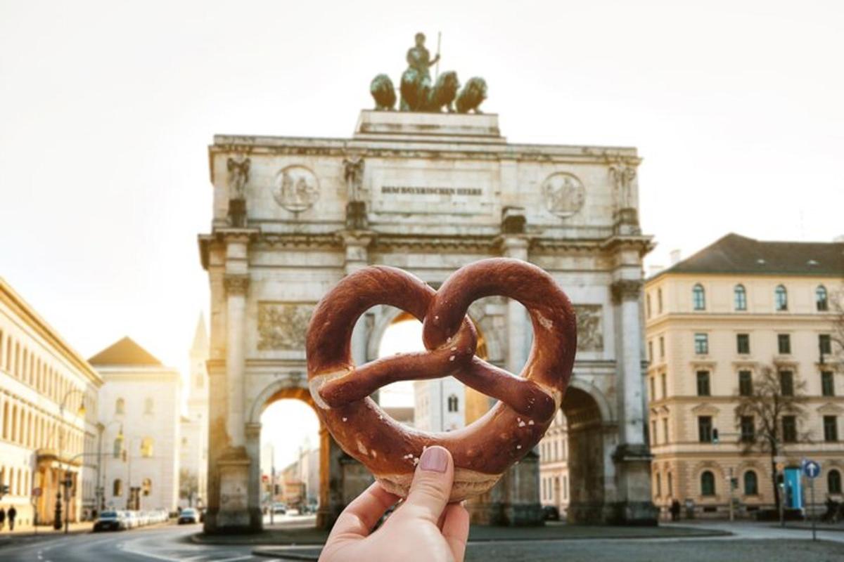 una persona che tiene in mano un pretzel davanti a un edificio