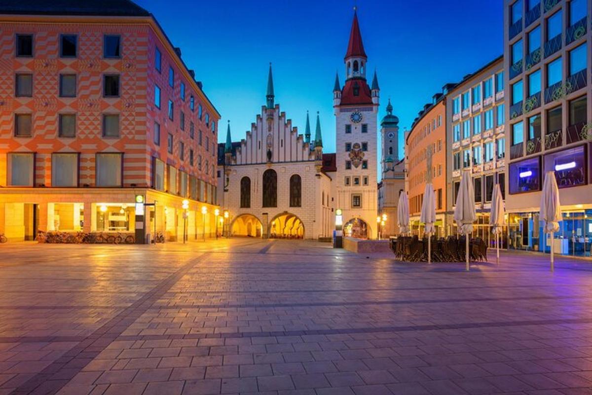 una strada cittadina con edifici e una torre dell'orologio di notte