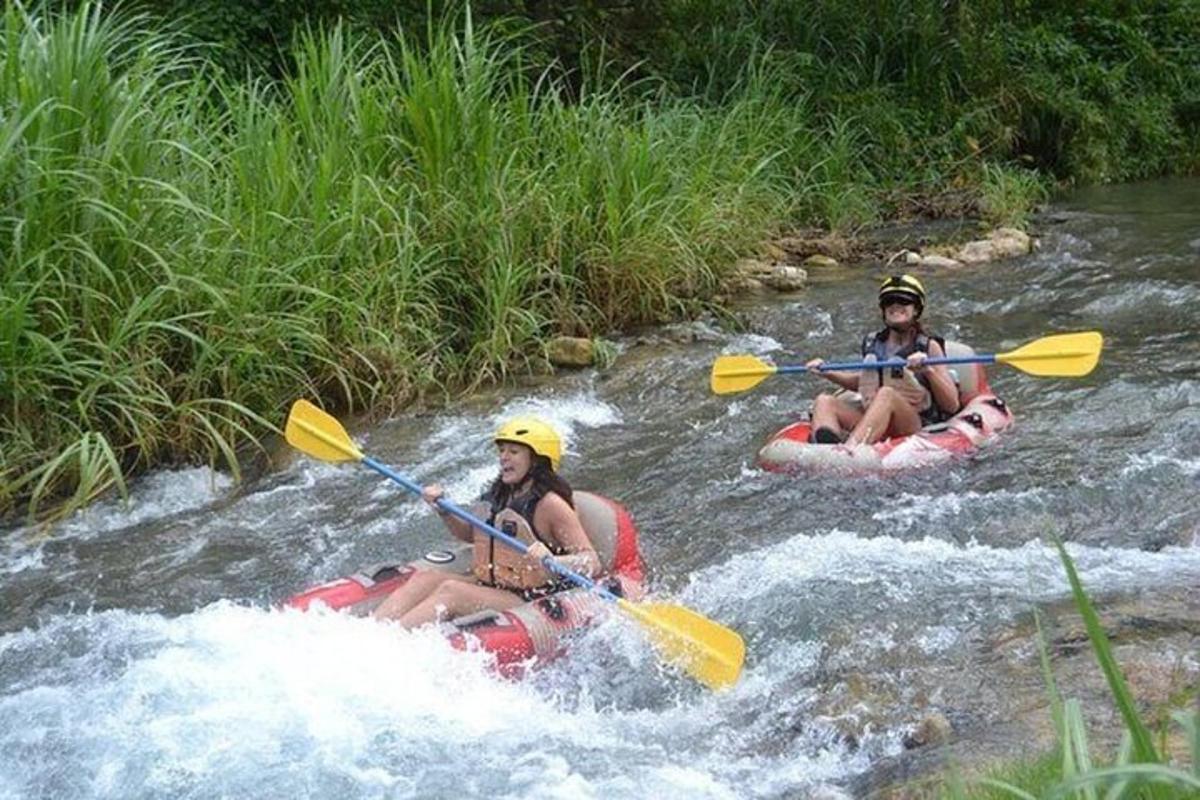 hai người đang chèo bè xuôi dòng sông trong ghềnh thác