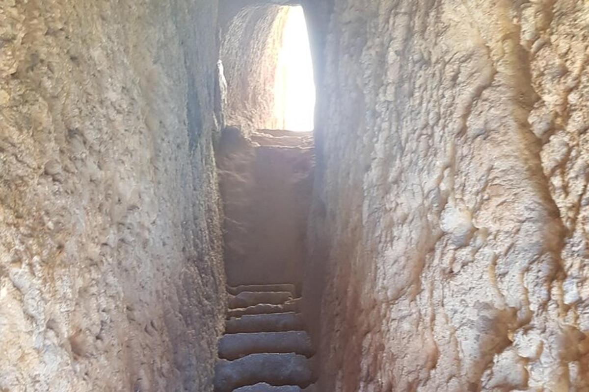 um beco com uma escada em um muro de pedra