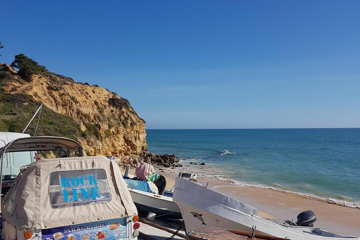 Un barco estacionado en la playa con un cartel en él.