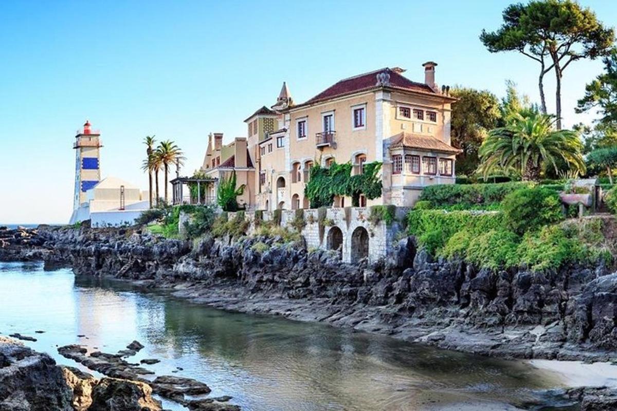 a house on the shore of a river with a lighthouse
