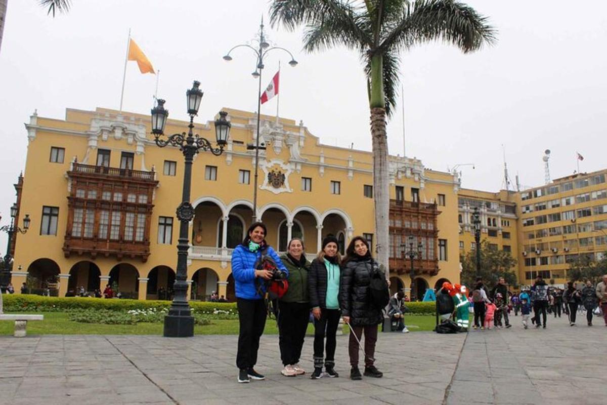 tres dones dempeus davant d'un edifici groc