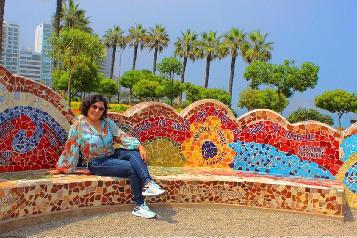 una dona asseguda en un banc cobert de mosaics