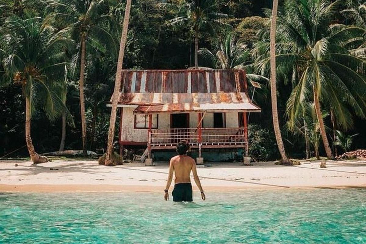 a man standing in the water in front of a house