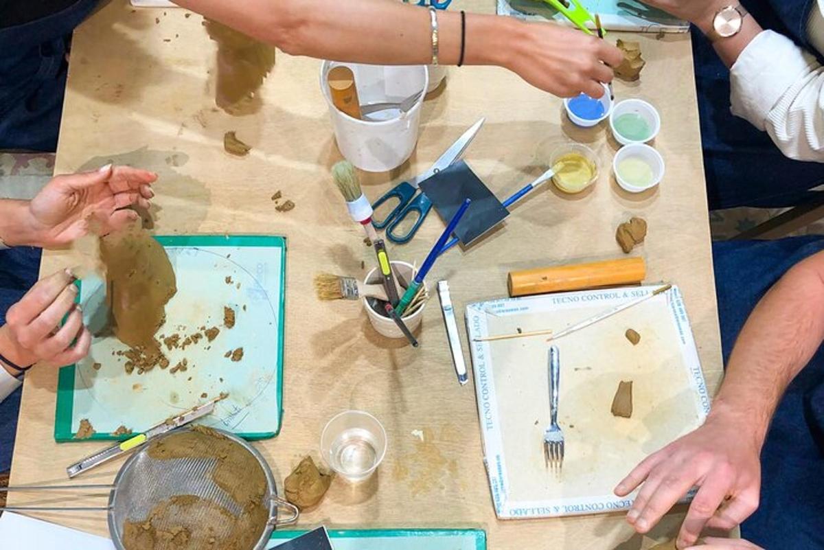 un gruppo di persone sedute attorno a un tavolo con materiali artistici