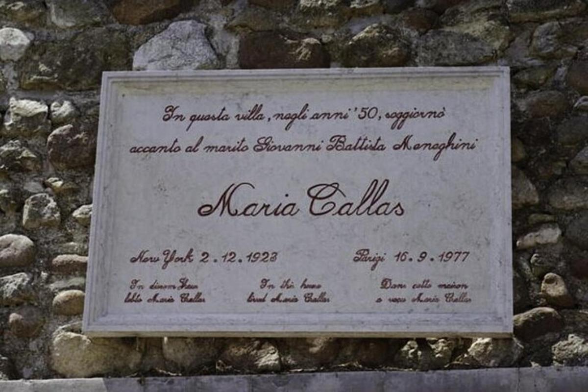 un cartel en el costado de un muro de piedra