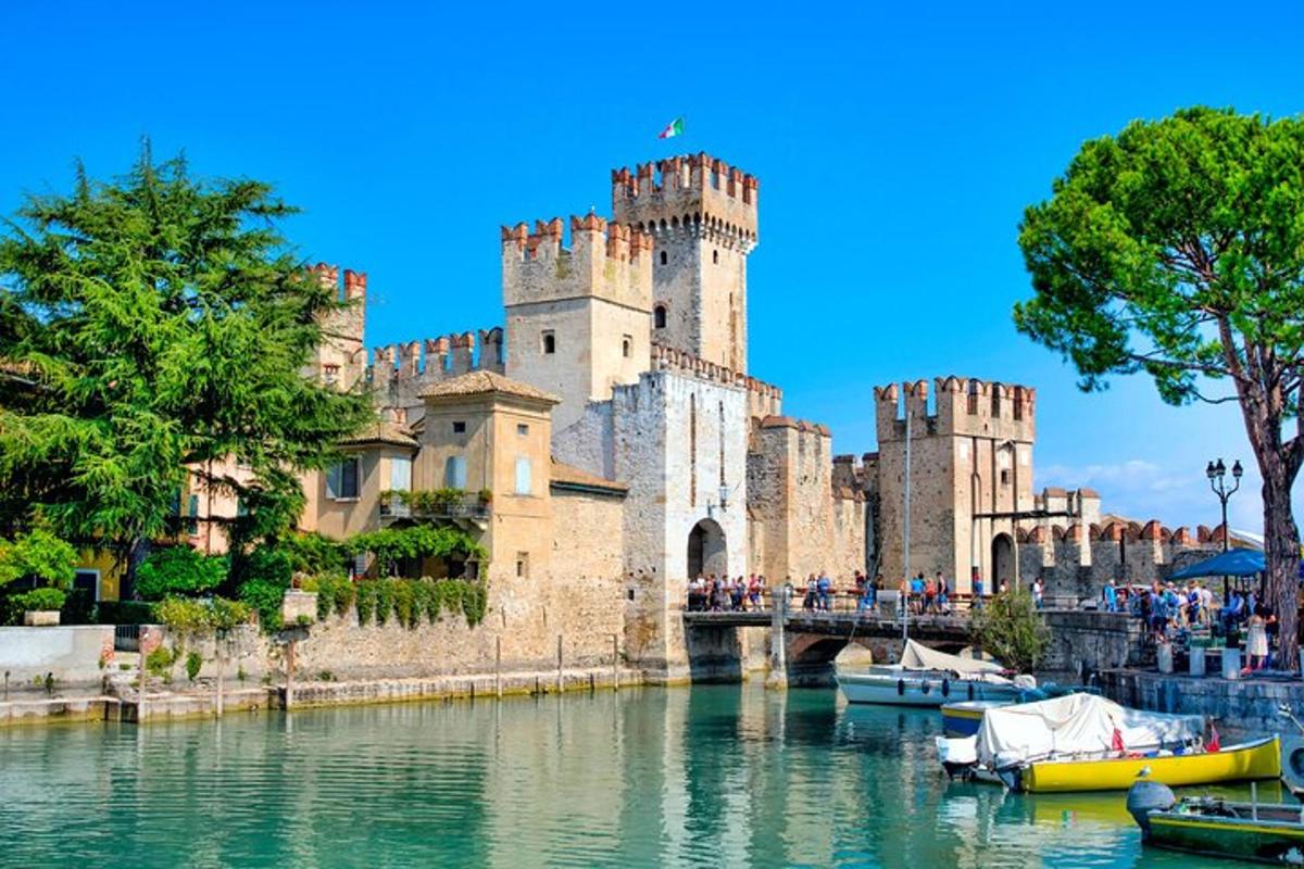 Un castillo con barcos en el agua frente a él.