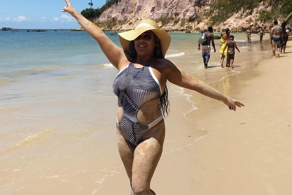 a woman in a hat standing on a beach