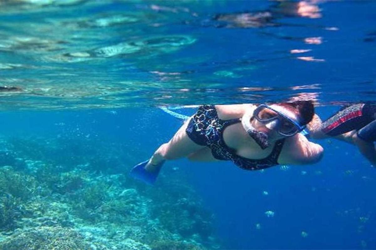žena plave ve vodě s brýlemi na hlavě