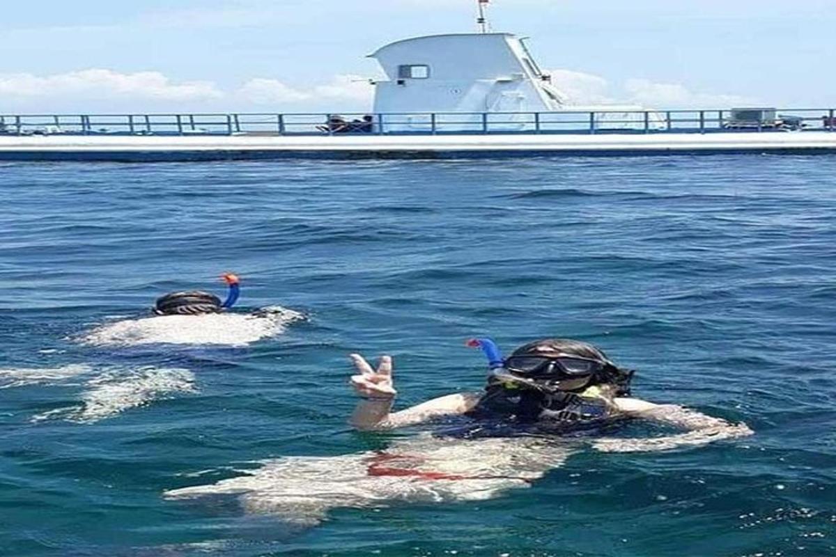 kaks inimest vees paadi kõrval