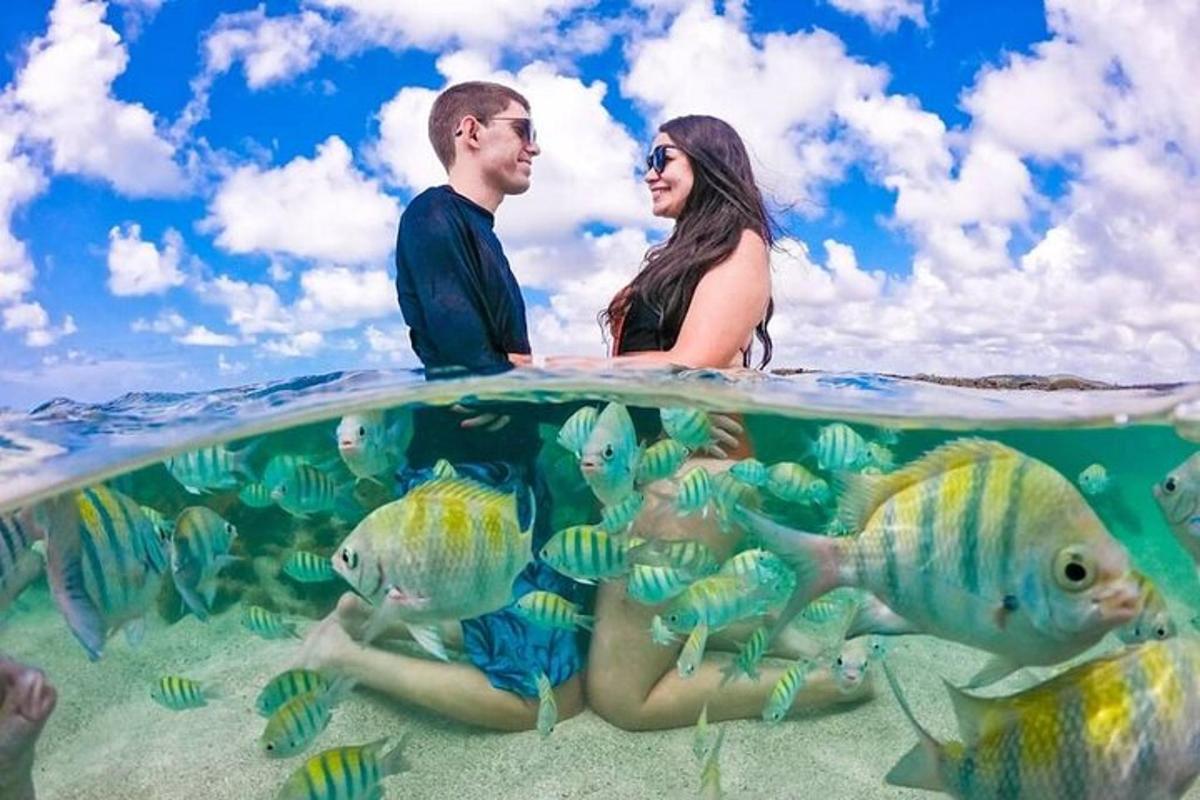 a couple sitting on top of the ocean with fish