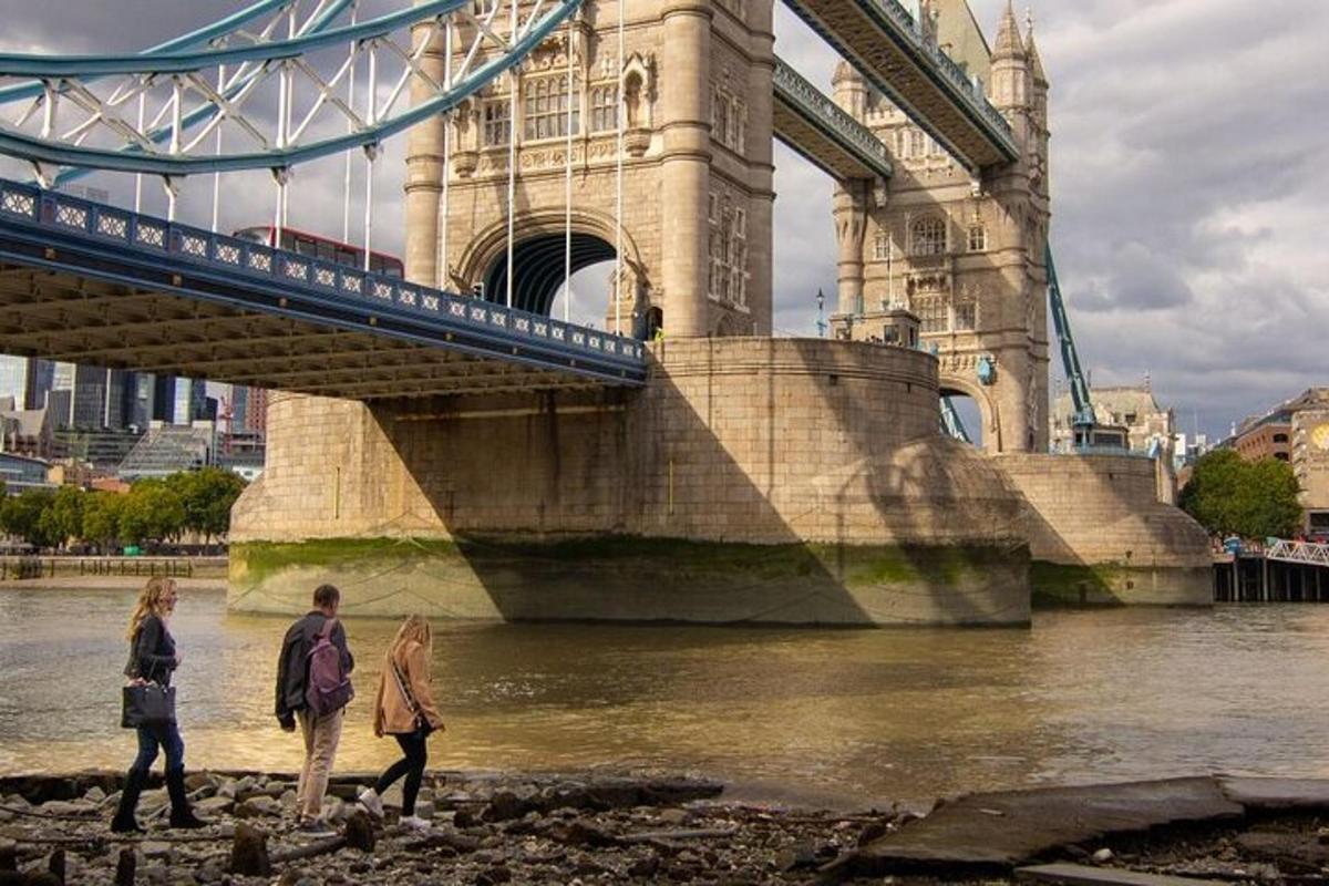 un gruppo di persone che camminano sotto un ponte
