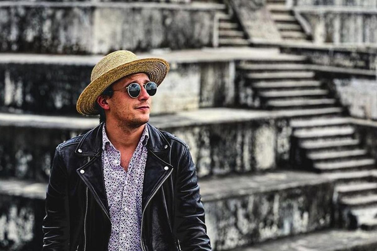 Un hombre que lleva un sombrero, una chaqueta de cuero y gafas de sol.
