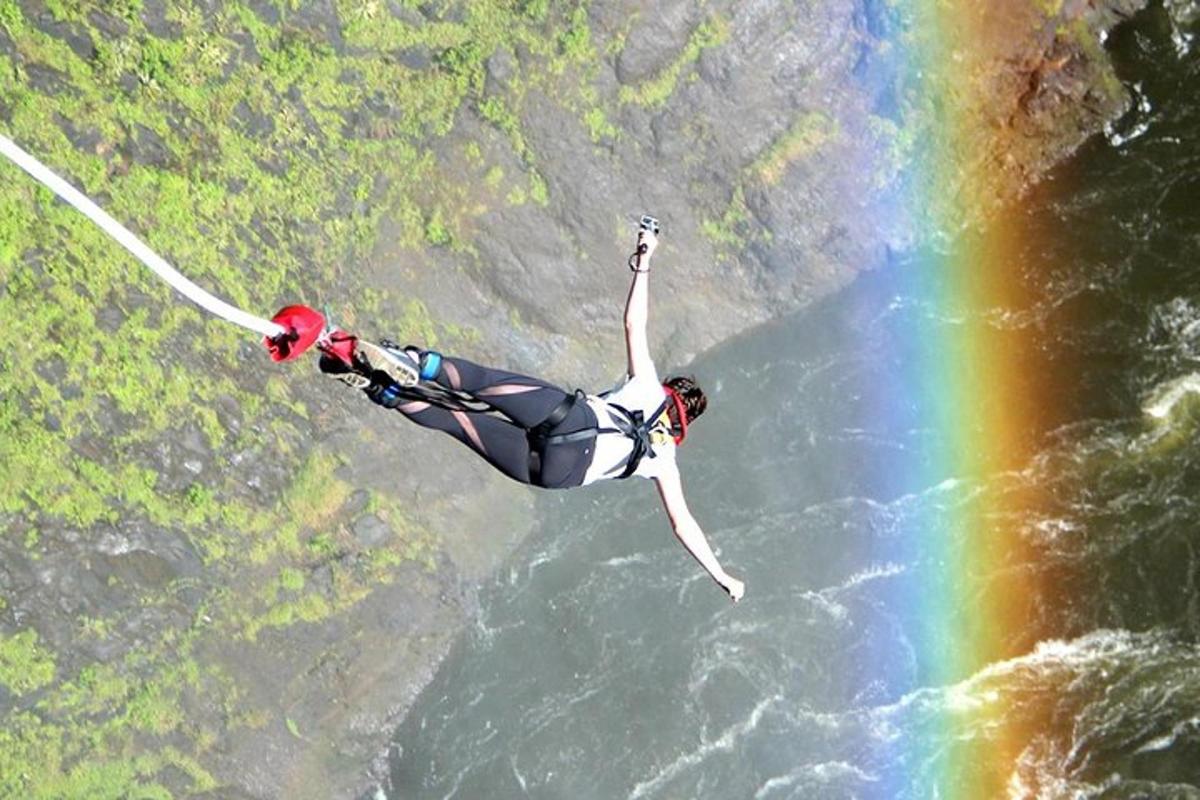 a person is in the water with a rainbow