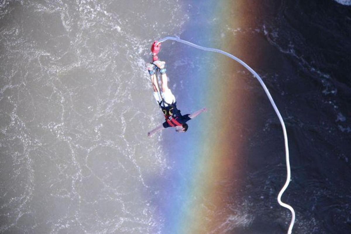a person is in the water with a rainbow