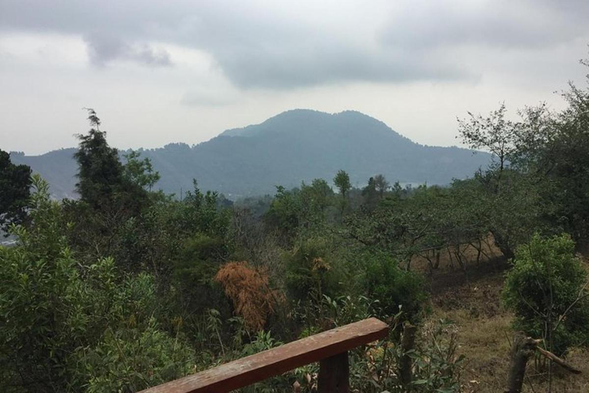 a bench on a hill with mountains in the background