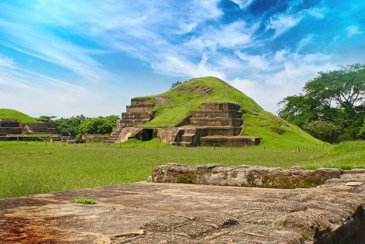 a pyramid with a green hill in a field