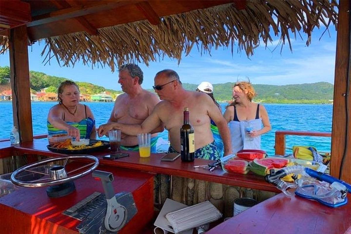 sekelompok orang berdiri di sekitar bar di atas perahu