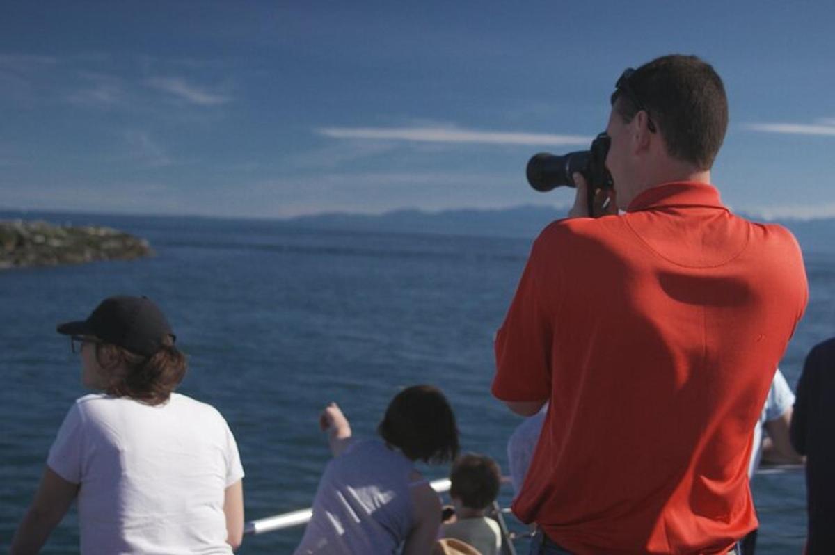 a man with a camera taking a picture of the water