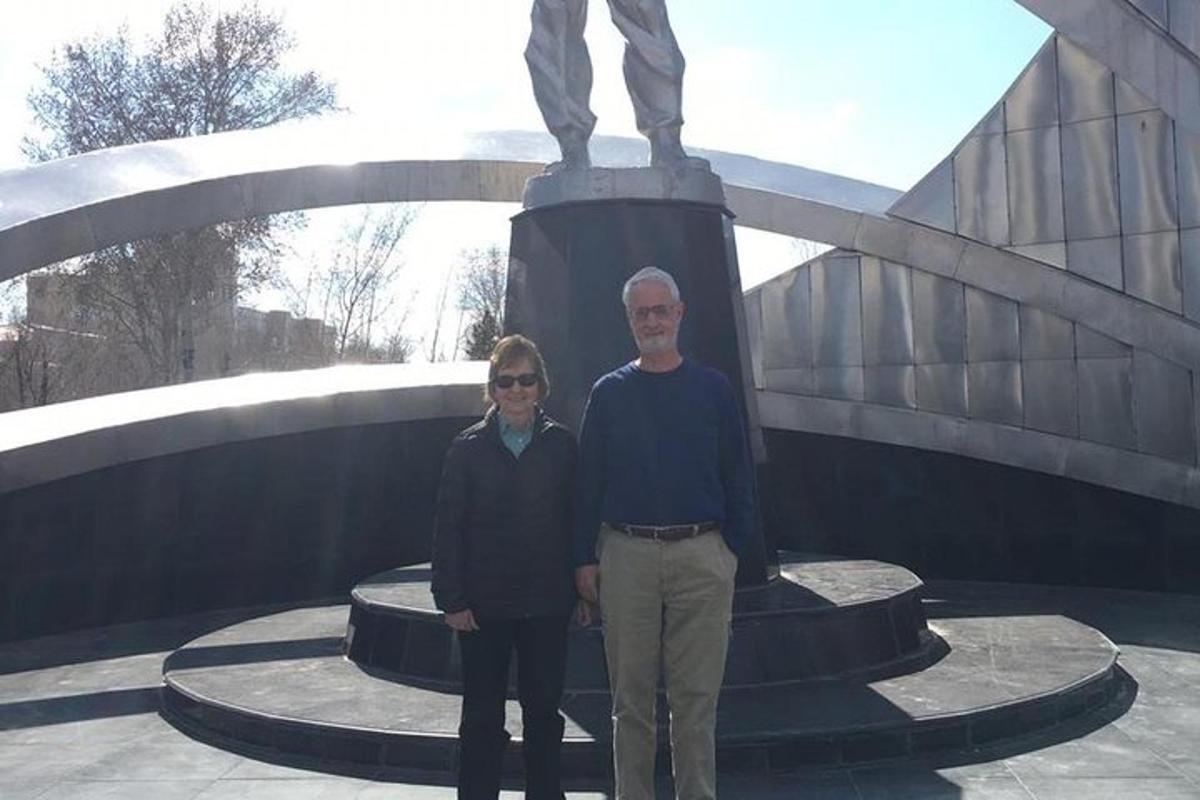 a man and a woman standing in front of a statue
