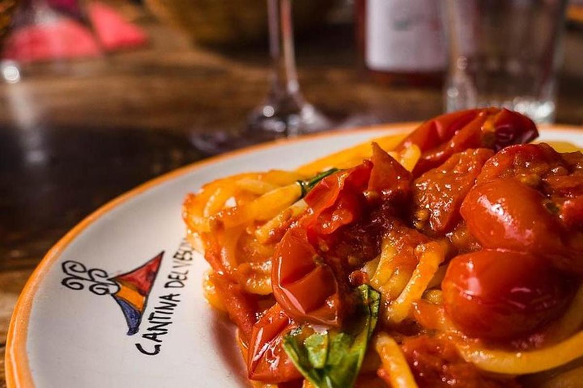 ein Teller mit Essen mit Nudeln und Tomaten auf einem Tisch