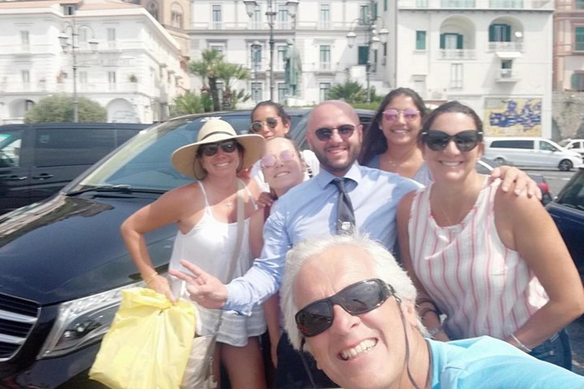 μια ομάδα ανθρώπων που στέκονται μπροστά από ένα αυτοκίνητο