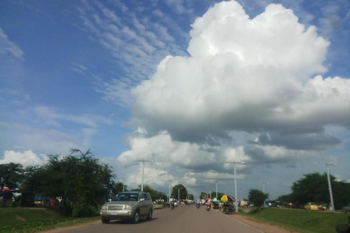 a truck driving down a road under a cloudy sky