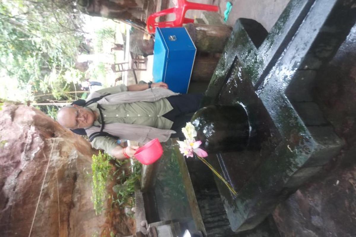a child is laying down next to a water fountain