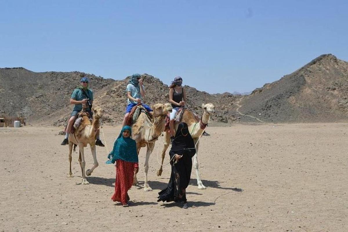un grup de persones muntades en camells al desert
