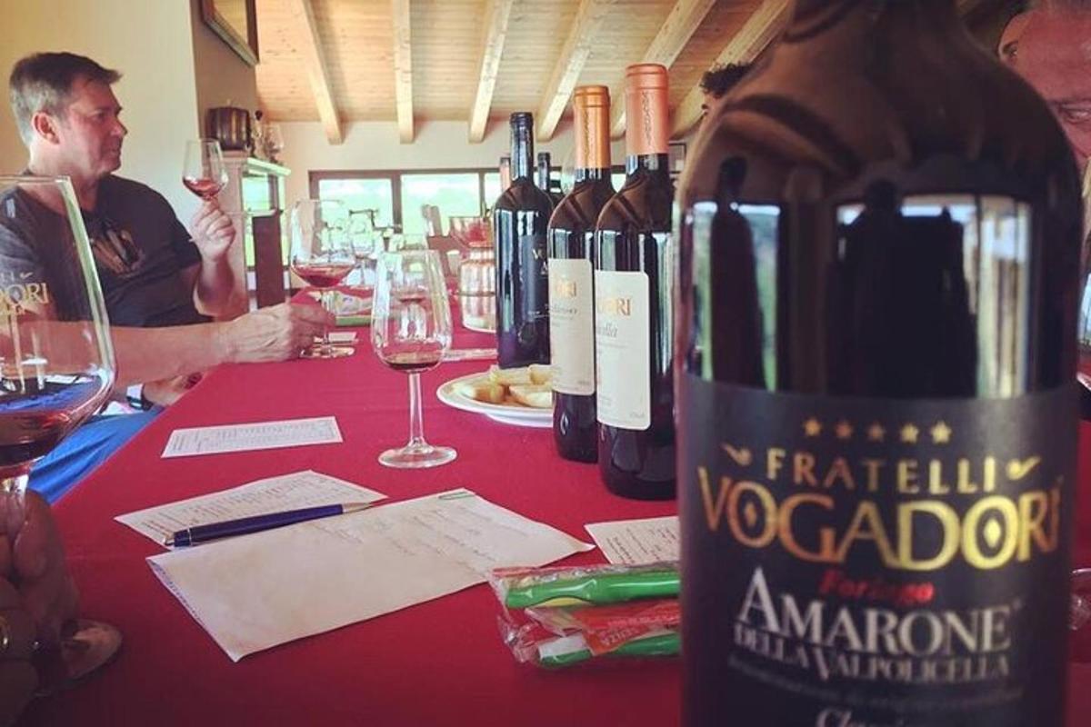 un uomo seduto a un tavolo con una bottiglia di vino