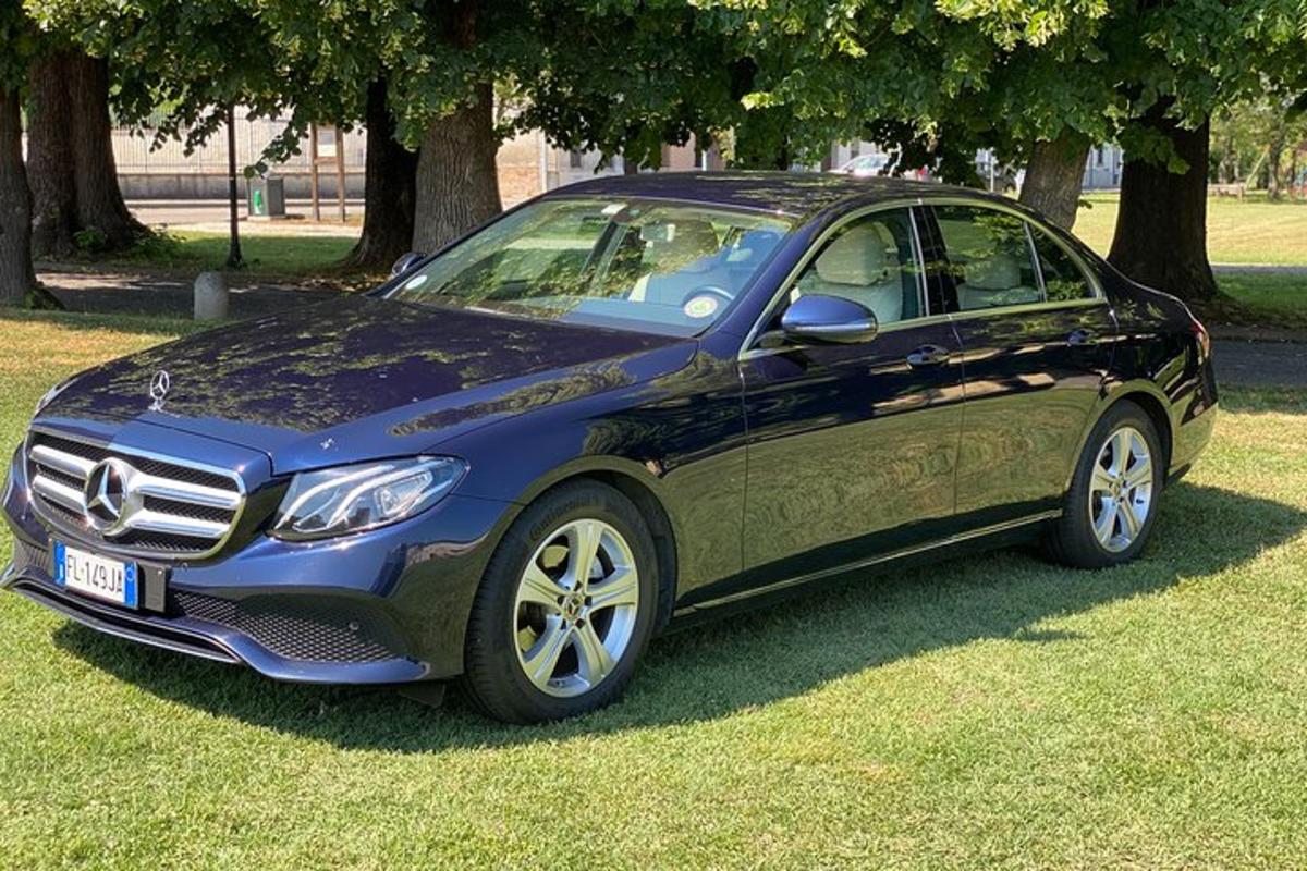 un'auto blu parcheggiata sull'erba in un campo