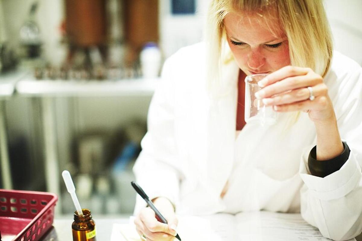 a woman sitting at a table drinking from a glass