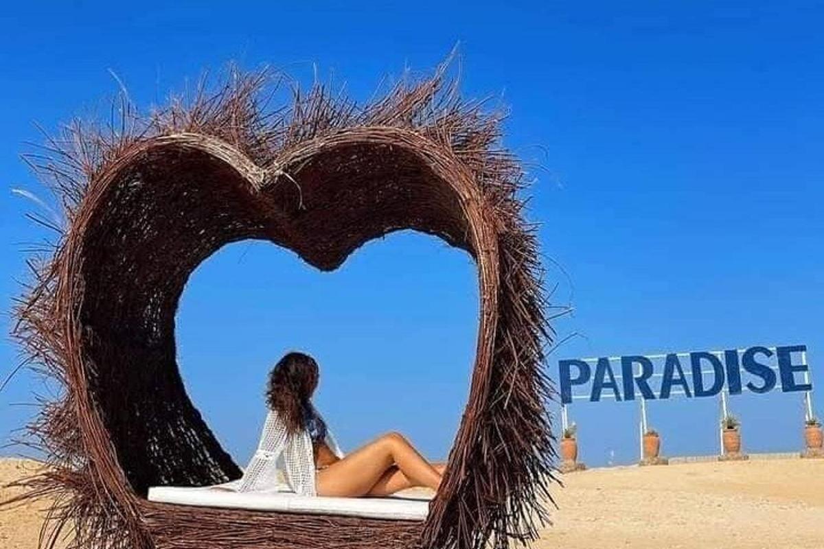 a woman sitting on a bed with a heart shape