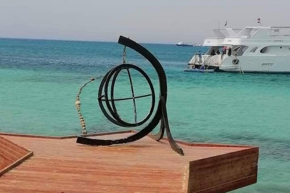 a metal ring on a dock with a boat in the water