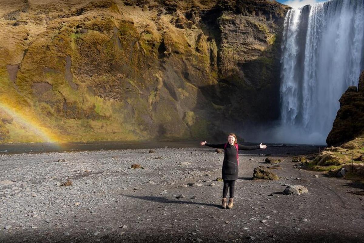 kona stendur fyrir framan foss