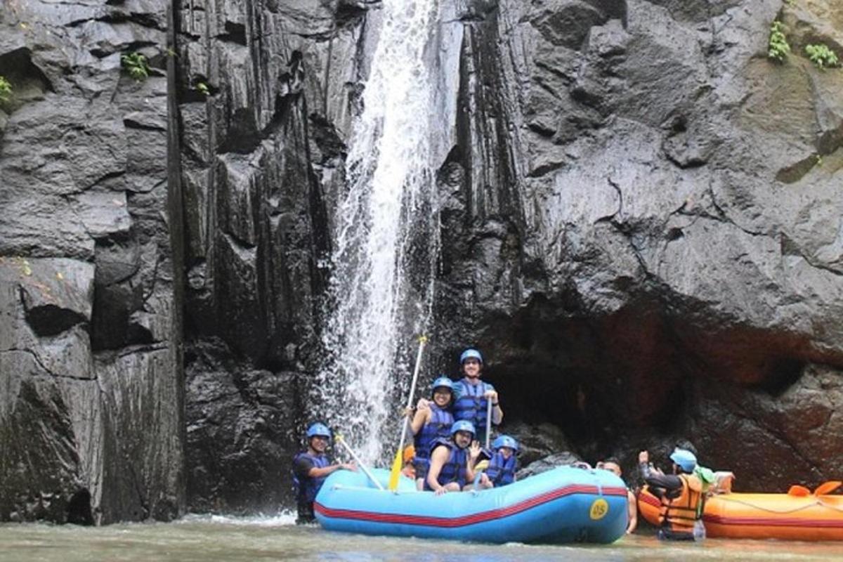un gruppo di persone su una zattera di fronte a una cascata